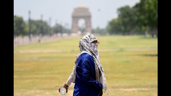 A woman with her face covered walks near the India Gate on a hot summer day during heatwave in New Delhi on June 17, 2024. (Photo by Money SHARMA / AFP) (AFP)