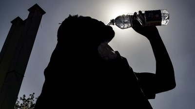 A passenger drinking water is silhouetted against the sun on a hot summer day at Jalandhar Cantonment railway station in Jalandhar on June 11, 2024 amid heatwave. Photo by Shammi MEHRA / AFP) (AFP) A passenger drinking water is silhouetted against the sun on a hot summer day at Jalandhar Cantonment railway station in Jalandhar on June 11, 2024 amid heatwave. Photo by Shammi MEHRA / AFP) (AFP)