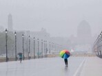People enjoy during a rain at the Kartavya Path in  New Delhi (Photo by Arvind Yadav/ Hindustan Times)