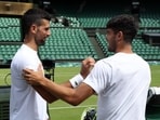 Serbia's Novak Djokovic shakes hands with Spain's Carlos Alcaraz during a practice session on centre court