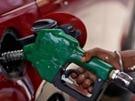 A worker holds a nozzle to pump petrol into a vehicle at a fuel station in Mumbai. A worker holds a nozzle to pump petrol into a vehicle at a fuel station in Mumbai.