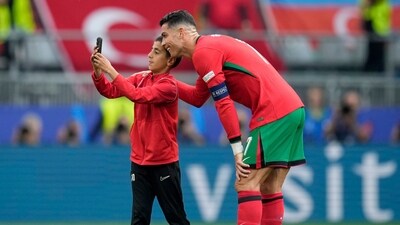 During Portugal's match against Turkey, a young child got past security and ran onto the pitch tot take a selfie with his idol Cristiano Ronaldo and the legend agreed with a smile. (AP) During Portugal's match against Turkey, a young child got past security and ran onto the pitch tot take a selfie with his idol Cristiano Ronaldo and the legend agreed with a smile. (AP)
