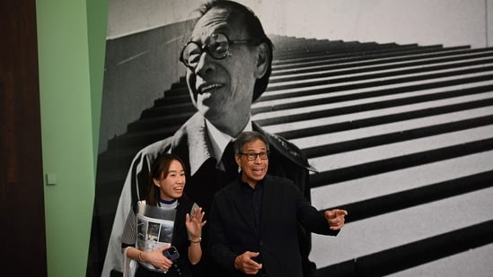 Sandi Pei (R), son of renowned Chinese-American architect I.M. Pei, is photographed in front of a photo of his father after a media preview of "I. M. Pei: Life Is Architecture", the first full-scale retrospective of I. M. Pei (1917-2019), one of the most influential architects of the twentieth and twenty-first centuries at the M+ art museum in Hong Kong. (AFP)