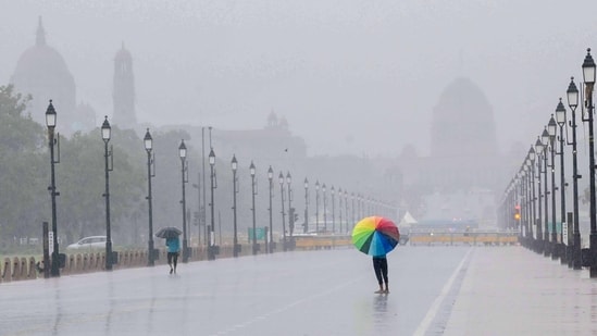 People enjoy during a rain at the Kartavya Path in New Delhi (Photo by Arvind Yadav/ Hindustan Times) (Hindustan Times)