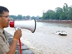 A Uttarakhand Police personnel advises people as the water level of river Ganga rises amid heavy rainfall, in Haridwar on Saturday. A Uttarakhand Police personnel advises people as the water level of river Ganga rises amid heavy rainfall, in Haridwar on Saturday.