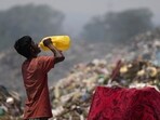 A waste picker drinks water while working during a heat wave at a garbage dump on the outskirts of Jammu, India, Wednesday, June 19, 2024. Waste pickers endure a miserable job that is growing more dangerous as climate change leads to rising heat. (AP Photo/Channi Anand)