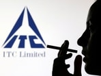 A woman poses with a cigarette in front of ITC Limited logo in this illustration. (Dado Ruvic/Reuters)