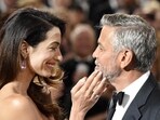 Actor/director George Clooney, right, is greeted by his wife Amal as he arrives in the ballroom at the 46th AFI Life Achievement Award gala honoring him at the Dolby Theatre.