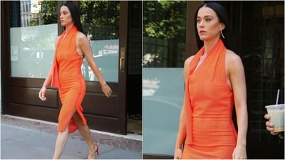 Katy Perry is adding a pop of colour to the streets of New York City in a vibrant orange dress paired with matching heels. Her straight hair complements the look, accented with pops of gold accessories. (Instagram) Katy Perry is adding a pop of colour to the streets of New York City in a vibrant orange dress paired with matching heels. Her straight hair complements the look, accented with pops of gold accessories. (Instagram)