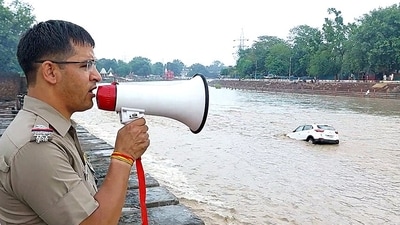 A Uttarakhand Police personnel advises people as the water level of river Ganga rises amid heavy rainfall, in Haridwar on Saturday. (ANI) A Uttarakhand Police personnel advises people as the water level of river Ganga rises amid heavy rainfall, in Haridwar on Saturday. (ANI)