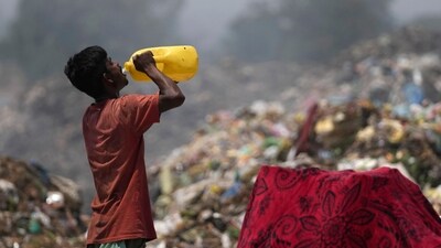 A waste picker drinks water while working during a heat wave at a garbage dump on the outskirts of Jammu, India, Wednesday, June 19, 2024. Waste pickers endure a miserable job that is growing more dangerous as climate change leads to rising heat. (AP Photo/Channi Anand) (AP)