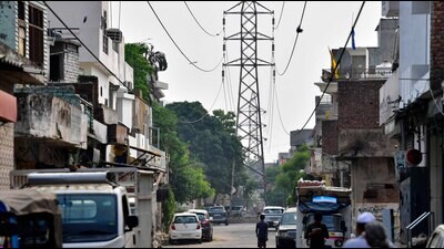 Commuters face a threat to their lives from extra high-tension (EHT) wires dangling over the New Chander Nagar main road. (Manish/ HT)