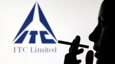 A woman poses with a cigarette in front of ITC Limited logo in this illustration. (Dado Ruvic/Reuters)