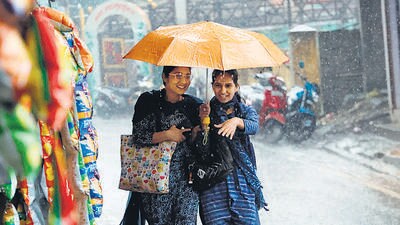 Residents using an umbrella to shield themselves from sudden showers in Mandi, Himachal. (Birbal Sharma/HT)