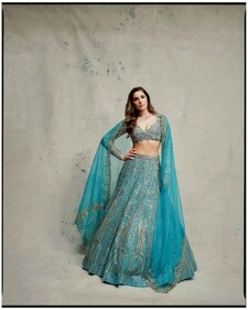 Ditching the predictable red or pastel lehenga for the bridal look, Nargis brings in a refreshing change in a blue hand embroidered lehenga with Swarovski crystal embellishment and zardozi work from Ruchika Hurria. The full-sleeved blouse adds a statement to this grandeur outfit. The lehenga has been styled with a diamond necklace featuring pear, oval, and round diamonds in prong settings and a pair of matching earrings from RK Jewellers.
(Photographer: Pulkit Mishra) Ditching the predictable red or pastel lehenga for the bridal look, Nargis brings in a refreshing change in a blue hand embroidered lehenga with Swarovski crystal embellishment and zardozi work from Ruchika Hurria. The full-sleeved blouse adds a statement to this grandeur outfit. The lehenga has been styled with a diamond necklace featuring pear, oval, and round diamonds in prong settings and a pair of matching earrings from RK Jewellers.
(Photographer: Pulkit Mishra)