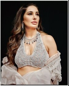 Bring in an air of romance to your pre-wedding look and take style cues from Nargis, who unleashes her playful streak in a halter neck top paired with straight fit pants in dori crystals and a ruffled structured cape from Akanksha Mago. The look has been rounded off with a diamond neckpiece inspired by flora of nature and blue sapphires and diamonds in oval, pear, marquise, round and emerald shapes with prong settings from RK Jewellers.
(Photographer: Pulkit Mishra) Bring in an air of romance to your pre-wedding look and take style cues from Nargis, who unleashes her playful streak in a halter neck top paired with straight fit pants in dori crystals and a ruffled structured cape from Akanksha Mago. The look has been rounded off with a diamond neckpiece inspired by flora of nature and blue sapphires and diamonds in oval, pear, marquise, round and emerald shapes with prong settings from RK Jewellers.
(Photographer: Pulkit Mishra)