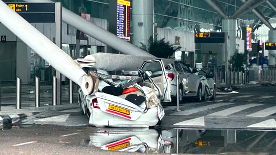 Parked vehicles are damaged by the collapse of a departure terminal canopy at New Delhi's Indira Gandhi International Airport (AP)