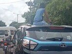 A video shared on social media shows a boy sitting on top of a Tata Nexon car during peak traffic hours in the city.