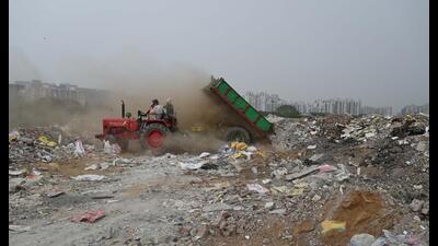 A tractor driver illegally dumping C&D waste on an empty plot of land in Gurugram. (HT PHOTO) A tractor driver illegally dumping C&D waste on an empty plot of land in Gurugram. (HT PHOTO)