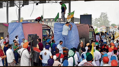 Led by the Bhartiya Kisan Union (Doaba) and Kisan Mazdoor Union, the protesters wrapped the toll plaza canopies in plastic sheets, tied them with ropes, and placed farmer union flags atop it. (Manish/HT) Led by the Bhartiya Kisan Union (Doaba) and Kisan Mazdoor Union, the protesters wrapped the toll plaza canopies in plastic sheets, tied them with ropes, and placed farmer union flags atop it. (Manish/HT)