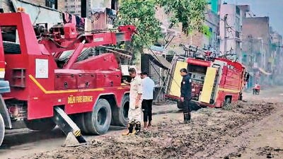 The fire tender (right) being pulled out of the mud on Sunday. (HT Photo) The fire tender (right) being pulled out of the mud on Sunday. (HT Photo)