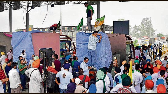 Led by the Bhartiya Kisan Union (Doaba) and Kisan Mazdoor Union, the protesters wrapped the toll plaza canopies in plastic sheets, tied them with ropes, and placed farmer union flags atop it. (Manish/HT)