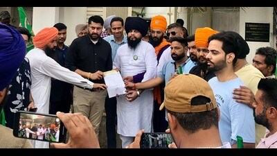 Farmers handing over a memorandum to BJP leader Sukhwinder Singh Bindra (in black shirt) outside his residence in Ludhiana on Monday. (HT Photo)