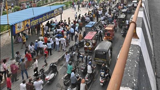 Crowd gathered near the spot where the woman and son climbed atop an overhead tank in Ludhiana on Monday. (Gurpreet Singh/HT)