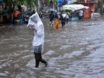 A man covers himself with a plastic sheet amid heavy rainfall in Surat. A man covers himself with a plastic sheet amid heavy rainfall in Surat.