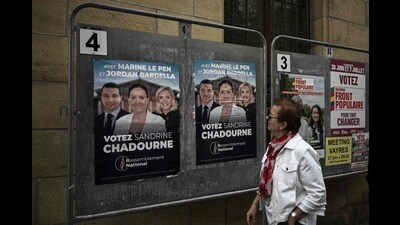 A woman looks at election posters of French far-right Rassemblement National (RN) candidate Sandrine Chadournec (C) in Libourne, southwestern France on July 2, 2024 as part of the French legislative elections. France's far right won the first round of pivotal legislative elections on June 30, 2024, with the centrist forces of France's President coming in only third behind the left after the highest turnout in over four decades. (Photo by Philippe LOPEZ / AFP) (AFP)