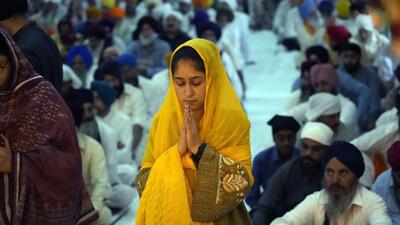 A woman pays obeisance at a gurudwara. (AP) A woman pays obeisance at a gurudwara. (AP)