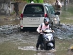 A commuter wades through a waterlogged road in Industrial Area, Chandigarh, following the rain on Tuesday morning. (Keshav Singh/HT)