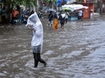 A man covers himself with a plastic sheet amid heavy rainfall in Surat. (File) A man covers himself with a plastic sheet amid heavy rainfall in Surat. (File)