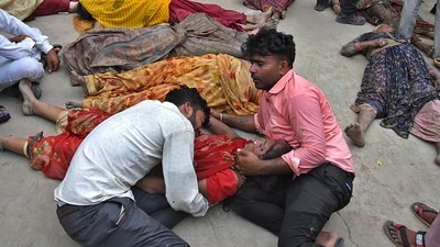 Relatives mourn next to the bodies of their relatives outside the Sikandrarao hospital in Hathras district on Tuesday. (AP) Relatives mourn next to the bodies of their relatives outside the Sikandrarao hospital in Hathras district on Tuesday. (AP)