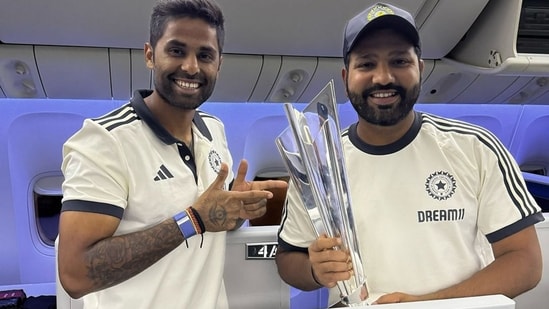 India's captain Rohit Sharma and Suryakumar Yadav pose with the ICC Men's T20 cricket World Cup 2024 trophy aboard a flight (PTI)
