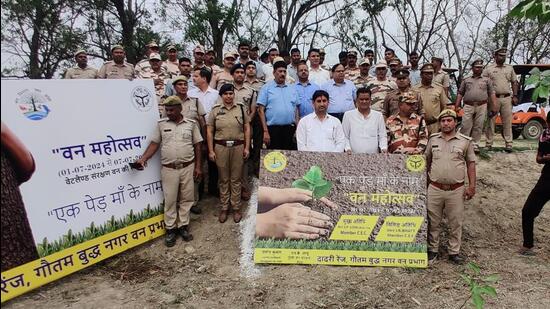 To mark the festival, around 150 people, including CISF personnel, ITBP personnel, school children, senior IFS officers, chief conservator of forests NK Janu, and local residents participated in planting sapling at the Surajpur wetland on Wednesday. (HT Photo)