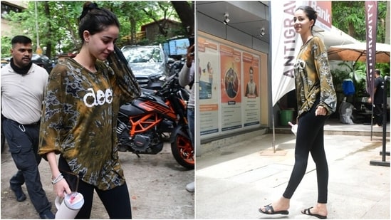 Ananya Panday's athleisure look at the gym features a tie-dye printed top with full-length sleeves and a round neckline. She tucked the blouse to add definition to the attire. Black tights, a messy bun, and flip-flops rounded off the gym look.&nbsp;(HT Photo/Varinder Chawla)