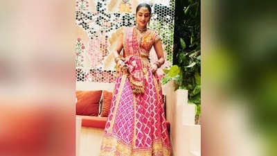 It features luxurious Banarasi brocade fabric in a stunning rani pink shade. The classic hand embroidery in gold taar zardozi adorned her attire, showcasing exquisite craftsmanship. Durga Maa shlokas were embroidered along the borders, and 35 meters of bandhej fabric were used to create the ghagra. Her beautiful V-neck blouse was inspired by a vintage Koti. (Instagram) It features luxurious Banarasi brocade fabric in a stunning rani pink shade. The classic hand embroidery in gold taar zardozi adorned her attire, showcasing exquisite craftsmanship. Durga Maa shlokas were embroidered along the borders, and 35 meters of bandhej fabric were used to create the ghagra. Her beautiful V-neck blouse was inspired by a vintage Koti. (Instagram)