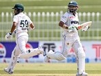 Pakistan's Mohammad Rizwan (R) and Saud Shakeel run between the wickets during the second day of the first Test against Bangladesh