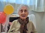 Maria Branyas, poses in front of a birthday cake on her 117th birthday in a nursing home, in Girona, Spain March.