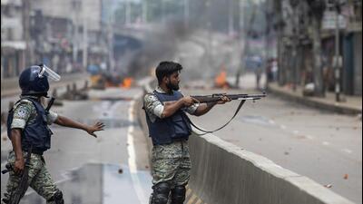 A policeman aims his weapon at protesters during a curfew imposed following violence during protests against Prime Minister Sheikh Hasina and her government, in Dhaka, Bangladesh, on August 5. (AP) A policeman aims his weapon at protesters during a curfew imposed following violence during protests against Prime Minister Sheikh Hasina and her government, in Dhaka, Bangladesh, on August 5. (AP)