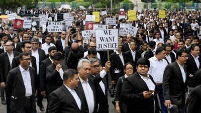 Calcutta high court advocates hold posters during a protest to condemn the rape and murder of a doctor in Kolkata on August 19, 2024. (AFP)