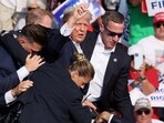 Republican presidential candidate and former U.S. President Donald Trump gestures with a bloodied face while he is assisted by U.S. Secret Service personnel after he was shot in the right ear during a campaign rally at the Butler Farm Show in Butler, Pennsylvania, U.S., July 13, 2024. REUTERS/Brendan McDermid/File Photo