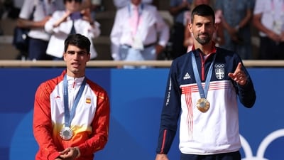 Gold medallist Novak Djokovic of Serbia gestures on the podium with silver medallist Carlos Alcaraz of Spain. (REUTERS)