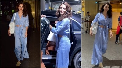 Kiara Advani made a stylish exit from Mumbai airport dressed in a comfy yet chic light blue co-ord ensemble. She wore a cropped shirt featuring front button closures, a knot detail on the hem, full sleeves, and notch lapel collars. She styled the blouse with flared pants, loafers, loose wavy tresses, a tote bag, and a no-makeup look. (Instagram) Kiara Advani made a stylish exit from Mumbai airport dressed in a comfy yet chic light blue co-ord ensemble. She wore a cropped shirt featuring front button closures, a knot detail on the hem, full sleeves, and notch lapel collars. She styled the blouse with flared pants, loafers, loose wavy tresses, a tote bag, and a no-makeup look. (Instagram)