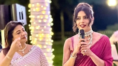 In one picture from inside the event, Priyanka was seen addressing the family and friends, speaking with a microphone in hand. Her mother, Madhu Chopra, was seen standing beside. In one picture from inside the event, Priyanka was seen addressing the family and friends, speaking with a microphone in hand. Her mother, Madhu Chopra, was seen standing beside.