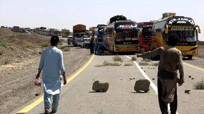 People walk past parked supply trucks alongside a road, after traffic was halted following an attack on a highway in Pakistan's restive province of Balochistan. (REUTERS) People walk past parked supply trucks alongside a road, after traffic was halted following an attack on a highway in Pakistan's restive province of Balochistan. (REUTERS)