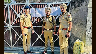 The police pasting seizure notice on a residential property in Ludhiana on Monday. (HT Photo)