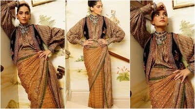 In this look, Sonam draped her printed saree like a skirt around her frame. As for the blouse, she wore a printed silk top featuring a round neckline, full-length sleeves, and cinched cuffs. She layered it with a black waistcoat featuring colourful embroidery on the borders. (Instagram) In this look, Sonam draped her printed saree like a skirt around her frame. As for the blouse, she wore a printed silk top featuring a round neckline, full-length sleeves, and cinched cuffs. She layered it with a black waistcoat featuring colourful embroidery on the borders. (Instagram)