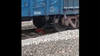 The image shows a train passing over a woman. Miraculously, she escaped unhurt. (Screengrab)